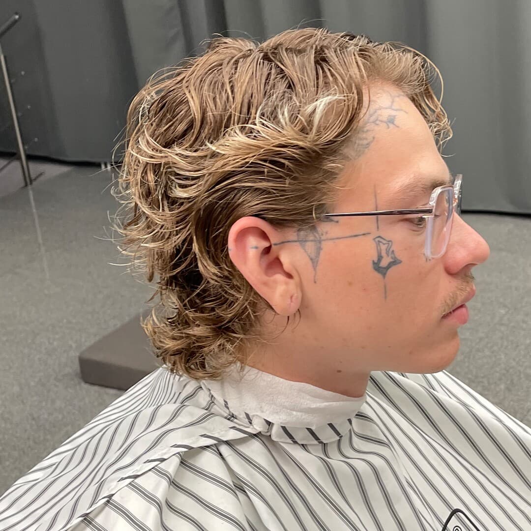 Dlhší kučeravý mullet so svetlými vlnami, profil — strihal Marek